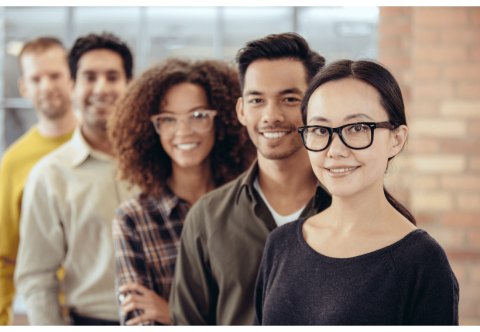 A photo of 5 people standing in a line and smiling